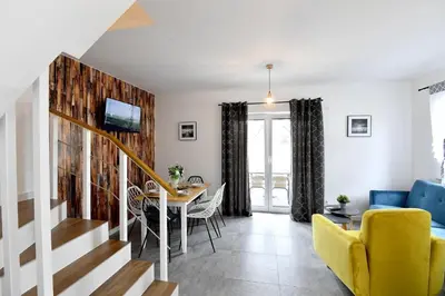 a living room with a table and a yellow chair at Domki na Krótkiej in Spytkowice