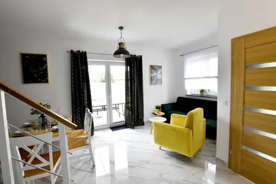 a living room with a yellow chair and a couch at Domki na Krótkiej in Spytkowice