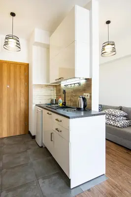 a kitchen with white cabinets and a counter top at ENERGYLANDIA Zator Apartament Krzyś in Zator