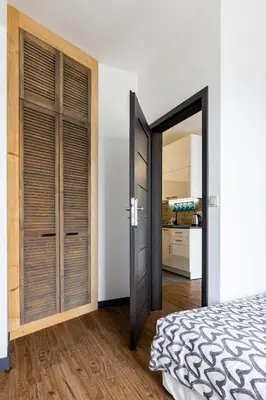 a bedroom with a door leading to a kitchen at ENERGYLANDIA Zator Apartament Krzyś in Zator