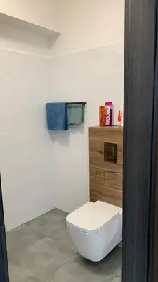 a bathroom with a white toilet and blue towels at ENERGYLANDIA Zator Apartament Krzyś in Zator