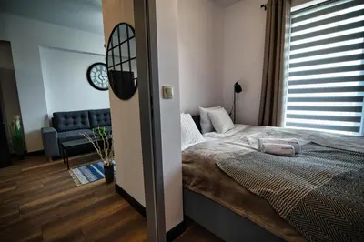 a bedroom with a bed and a couch and a clock at LOFT 24 by Housine in Zator