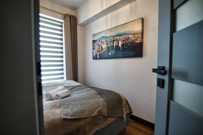 a bedroom with a bed and a painting on the wall at LOFT 24 by Housine in Zator