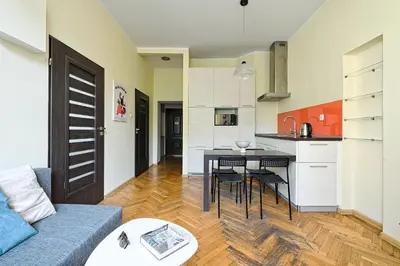 a kitchen and living room with a couch and a table at Urban Nest Apartments Dietla 69 in Kraków