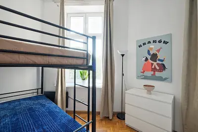 a bedroom with a bunk bed with a blue bedspread at Urban Nest Apartments Dietla 69 in Kraków