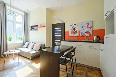 a kitchen and living room with a table and a couch at Urban Nest Apartments Dietla 69 in Kraków