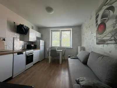 a living room with a couch and a kitchen at Kalwaryjska Spot Apartment in a Good Location in Kraków