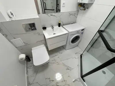 a bathroom with a toilet sink and a washing machine at Kalwaryjska Spot Apartment in a Good Location in Kraków