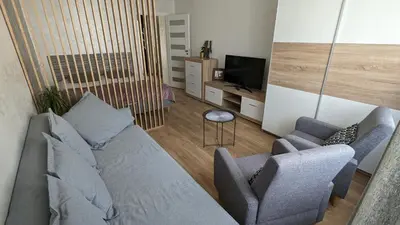 a living room with a couch and two chairs and a television at Kalwaryjska Spot Apartment in a Good Location in Kraków