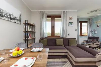 a living room with a couch and a table at Apartment Na Zakolu Wisły by Noclegi Renters in Kraków