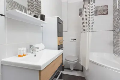 a white bathroom with a sink and a toilet at Apartment Na Zakolu Wisły by Noclegi Renters in Kraków