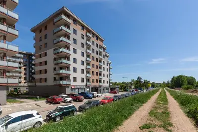 a parking lot with cars parked next to a tall building at Apartment Na Zakolu Wisły by Noclegi Renters in Kraków