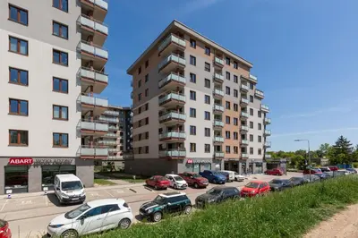 a parking lot with cars parked next to a tall building at Apartment Na Zakolu Wisły by Noclegi Renters in Kraków