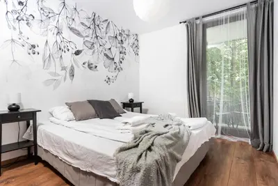 a bedroom with a bed and a wall with a tree mural at Blossom - Old Town Residence - by Upstairs in Kraków
