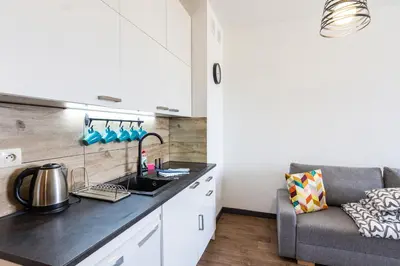 a kitchen with a sink and a couch in a room at ENERGYLANDIA Zator Apartament Grześ in Zator