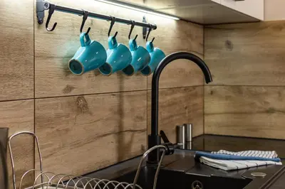 a kitchen with blue mugs hanging on a wall at ENERGYLANDIA Zator Apartament Grześ in Zator