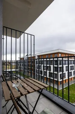 a balcony with a wooden bench and a building at ENERGYLANDIA Zator Apartament Grześ in Zator