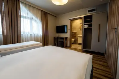 a hotel room with a bed and a television at Villa & Gospoda Krakowska in Kobiernice