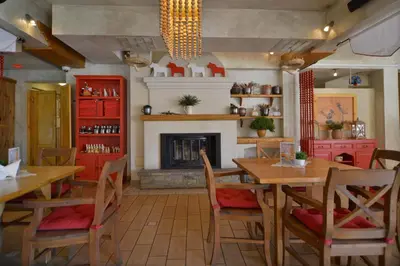 a dining room with wooden tables and a fireplace at Villa & Gospoda Krakowska in Kobiernice