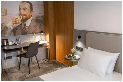 a hotel room with a bed and a painting of a man at Art Boutique in Kraków