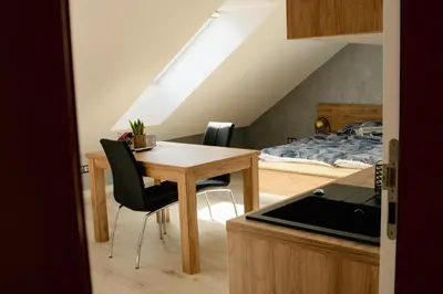 a kitchen and dining room with a table and a bed at Apartamenty Jordanów - Stacja Paliw MOYA in Jordanów