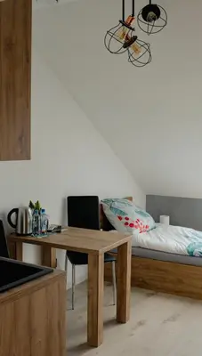 a room with a desk and a bed with a table at Apartamenty Jordanów - Stacja Paliw MOYA in Jordanów