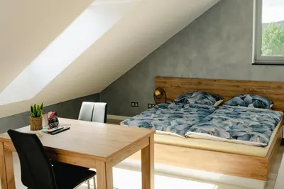 a bedroom with a bed and a wooden table at Apartamenty Jordanów - Stacja Paliw MOYA in Jordanów