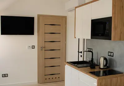 a kitchen with white cabinets and a counter top at Apartamenty Jordanów - Stacja Paliw MOYA in Jordanów