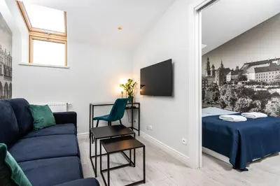 a living room with a couch and a bed and a mirror at Ariańska apartment - Cracow, city centre in Kraków