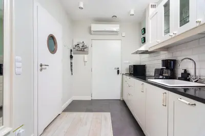 a kitchen with white cabinets and a white door at Ariańska apartment - Cracow, city centre in Kraków