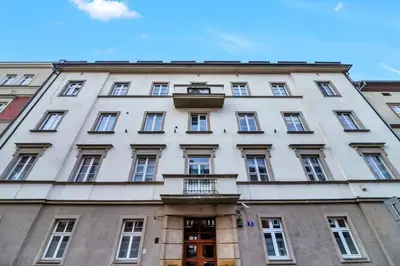 a large white building with windows and a balcony at Ariańska apartment - Cracow, city centre in Kraków