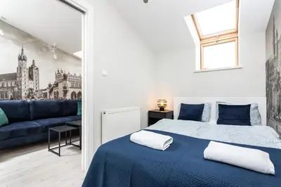 a bedroom with a blue bed and a blue couch at Ariańska apartment - Cracow, city centre in Kraków