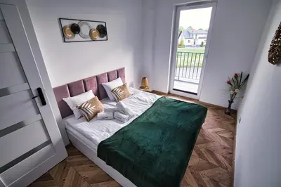 a bedroom with a bed with a green blanket on it at Kalimera 18 by Housine in Zator