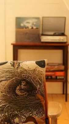 a bed with a pillow with a laptop on a table at Domek Mały Las in Rzyki