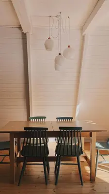 a wooden table with four chairs and lights at Domek Mały Las in Rzyki