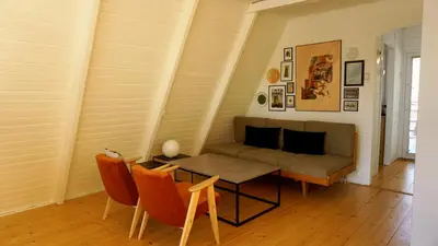 a living room with a couch and a table and chairs at Domek Mały Las in Rzyki