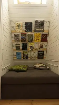 a room with a bed with a wall of books at Domek Mały Las in Rzyki