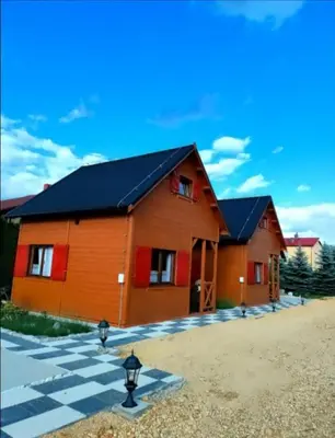 a room with a bed in a wooden cabin at Domki Na Winnicy Zator Przeciszów in Przeciszów