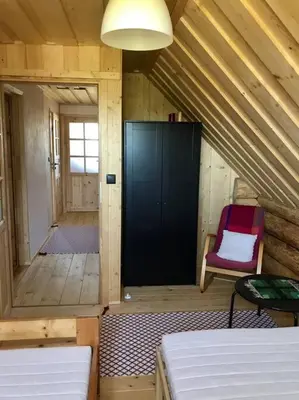 a room with two beds and a chair in a cabin at Chatka_Kasina in Kasina Wielka