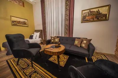 a hotel room with a desk and a table at Ars Cracovia Apartments in Kraków
