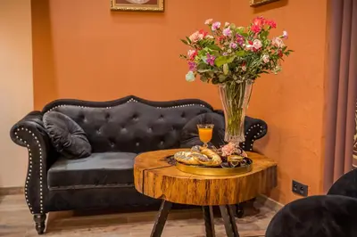 a coffee table with a vase of flowers and a bowl of food on it at Ars Cracovia Apartments in Kraków