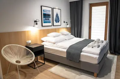 a bedroom with a large bed and a chair at Riviera Camp in Radłów