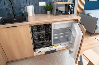 an open dishwasher in a kitchen under a counter at Riviera Camp in Radłów