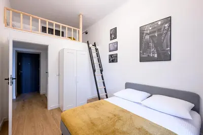 a bedroom with a bed and a ladder on the wall at Native Apartments Paulińska 20 Deluxe in Kraków