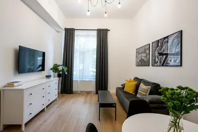 a living room with a couch and a tv at Native Apartments Paulińska 20 Deluxe in Kraków