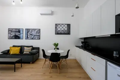 a kitchen and living room with a table and a couch at Native Apartments Paulińska 20 Deluxe in Kraków