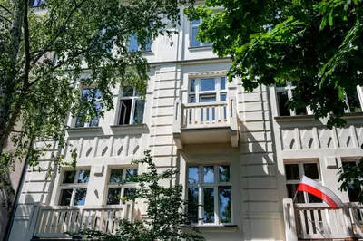 a white building with windows and a balcony at Native Apartments Paulińska 20 Deluxe in Kraków