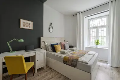 a bedroom with a bed and a desk and a window at Urban Nest Apartments Blich 8 in Kraków