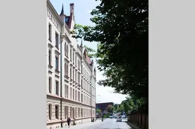 a building on the side of a street next to a tree at Urban Nest Apartments Blich 8 in Kraków