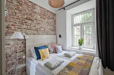 a bedroom with a brick wall and a bed with pillows at Urban Nest Apartments Blich 8 in Kraków